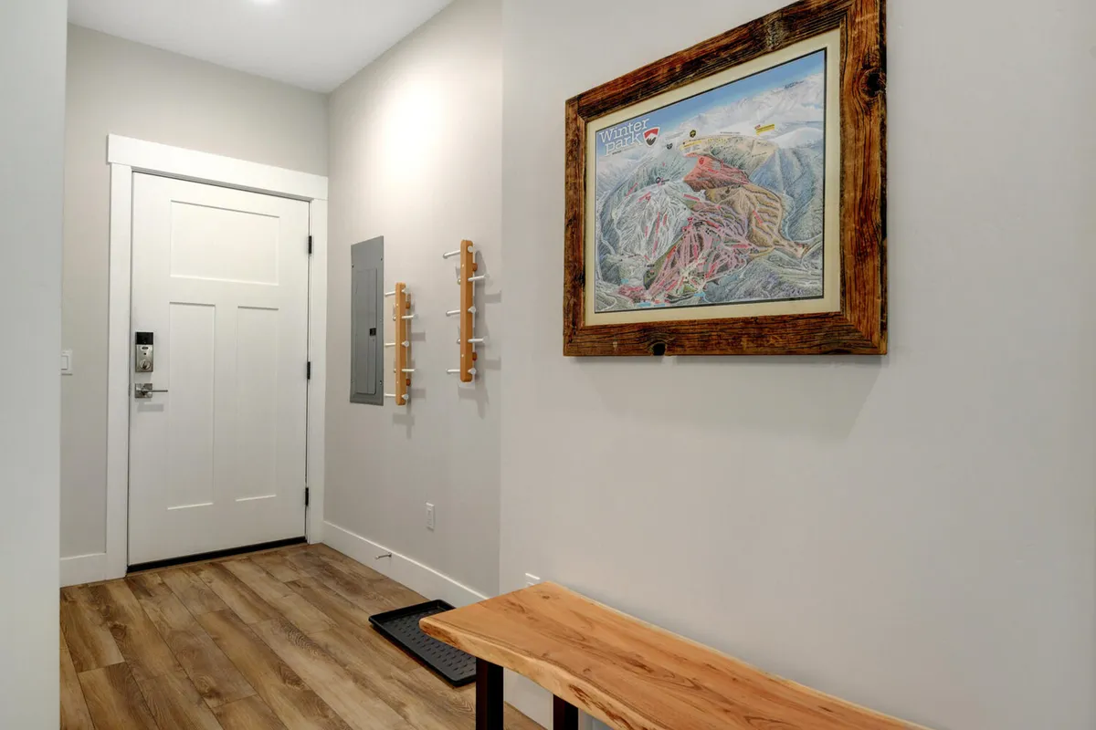 A welcoming entryway featuring a wooden bench, coat hooks, and local artwork on the wall. The space is inviting, functional, and gives a sense of arrival, hinting at the adventures waiting beyond the door.