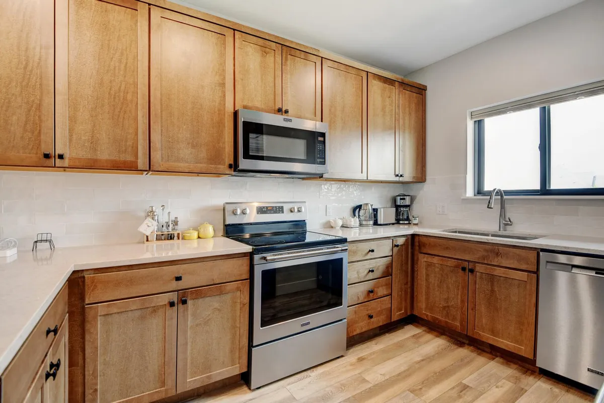 A bright, functional kitchen with modern stainless steel appliances, ample cabinetry, and a sunlit window. The layout is perfect for meal preparation and family gatherings, providing plenty of space for cooking and togetherness.